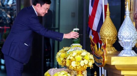 Former Thai Prime Minister Thaksin Shinawatra, who is expected to be arrested upon his return as he ends almost two decades of self-imposed exile, pays his respects to a portrait of Thailand's King Maha Vajiralongkorn and Queen Suthida at Don Mueang airport in Bangkok, Thailand August 22, 2023. REUTERS/Athit Perawongmetha